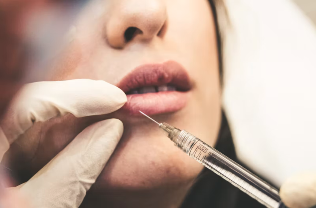 Médecin faisant une injection esthétique dans  la lèvre d'une femme