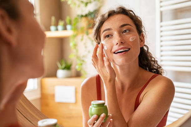 Femme s'appliquant un soin du visage faisant partie des cosmétiques naturels