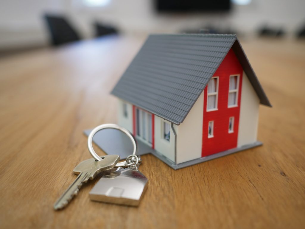 Maison miniature avec des clés à coté signifiant la signature d'un bail de location