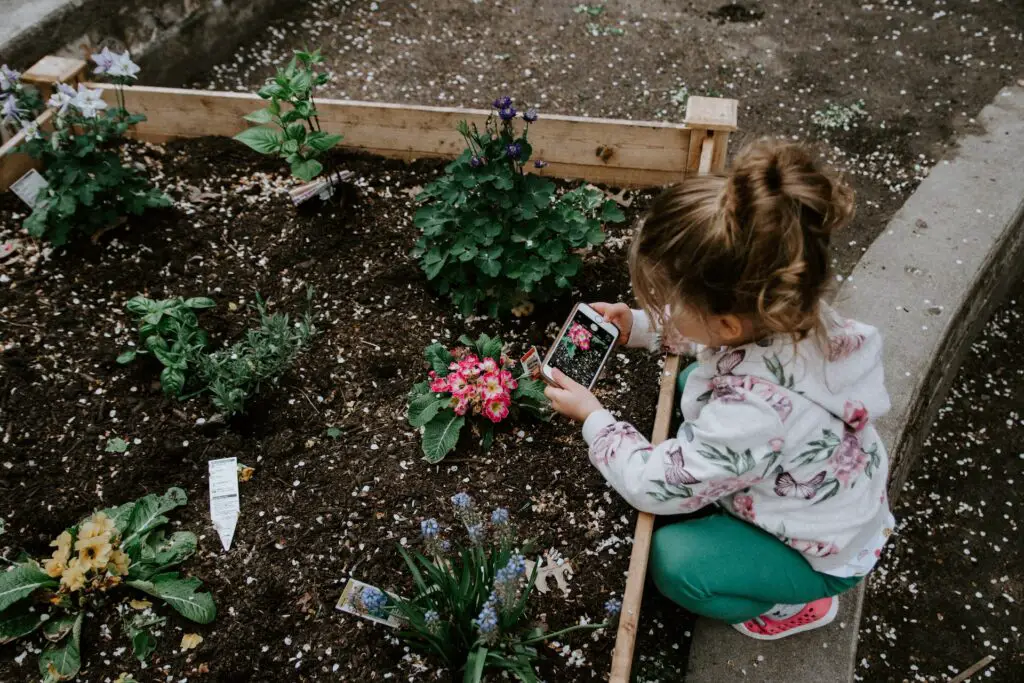 Petite fille plaçant les étiquettes des plantes dans un jardin