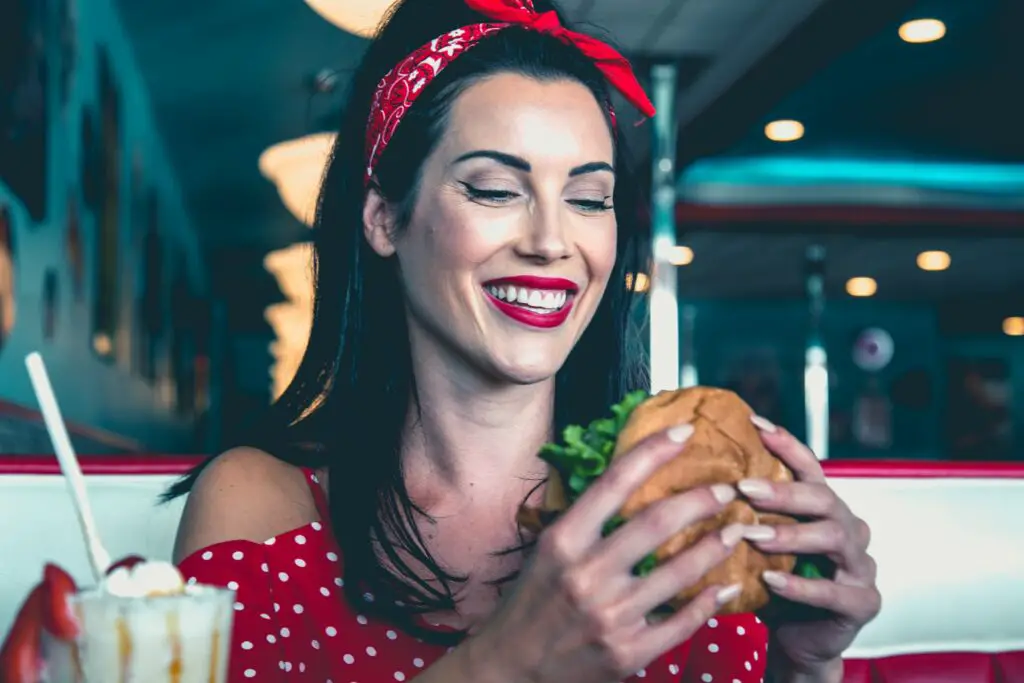 Femme avec un style vintage mangeant un burger
