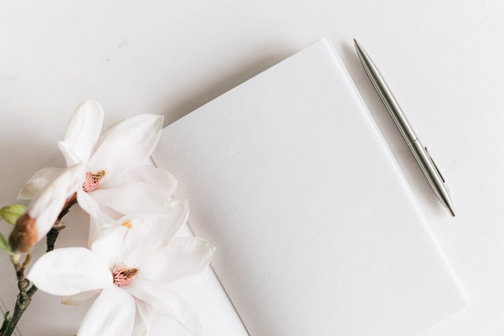 Cahier d'écriture avec pages blanches et une fleur et un stylo